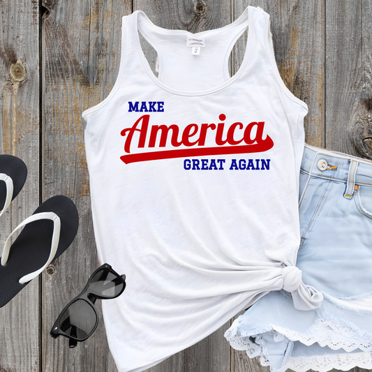 White Make America Great Again tank top flat laid on a wooden table with USA flag-themed accessories