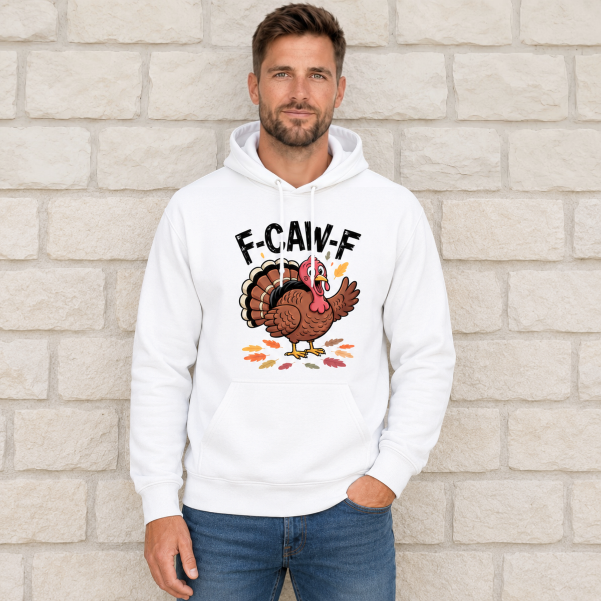 Man wearing a white hoodie with a colorful F-CAW-F turkey graphic against a light stone wall.