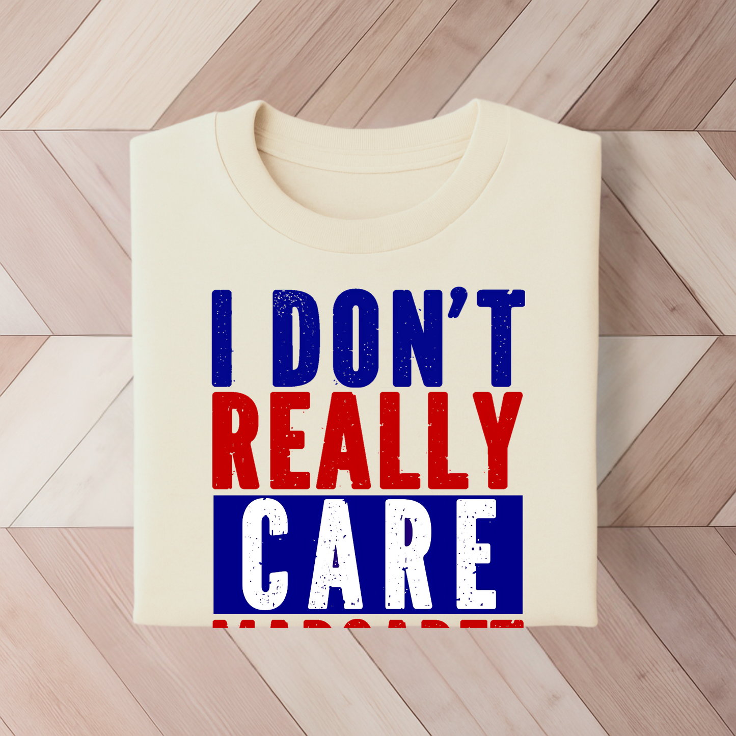 Sand colored t-shirt with bold red, white, and blue text reading "I Don’t Really Care Margaret"