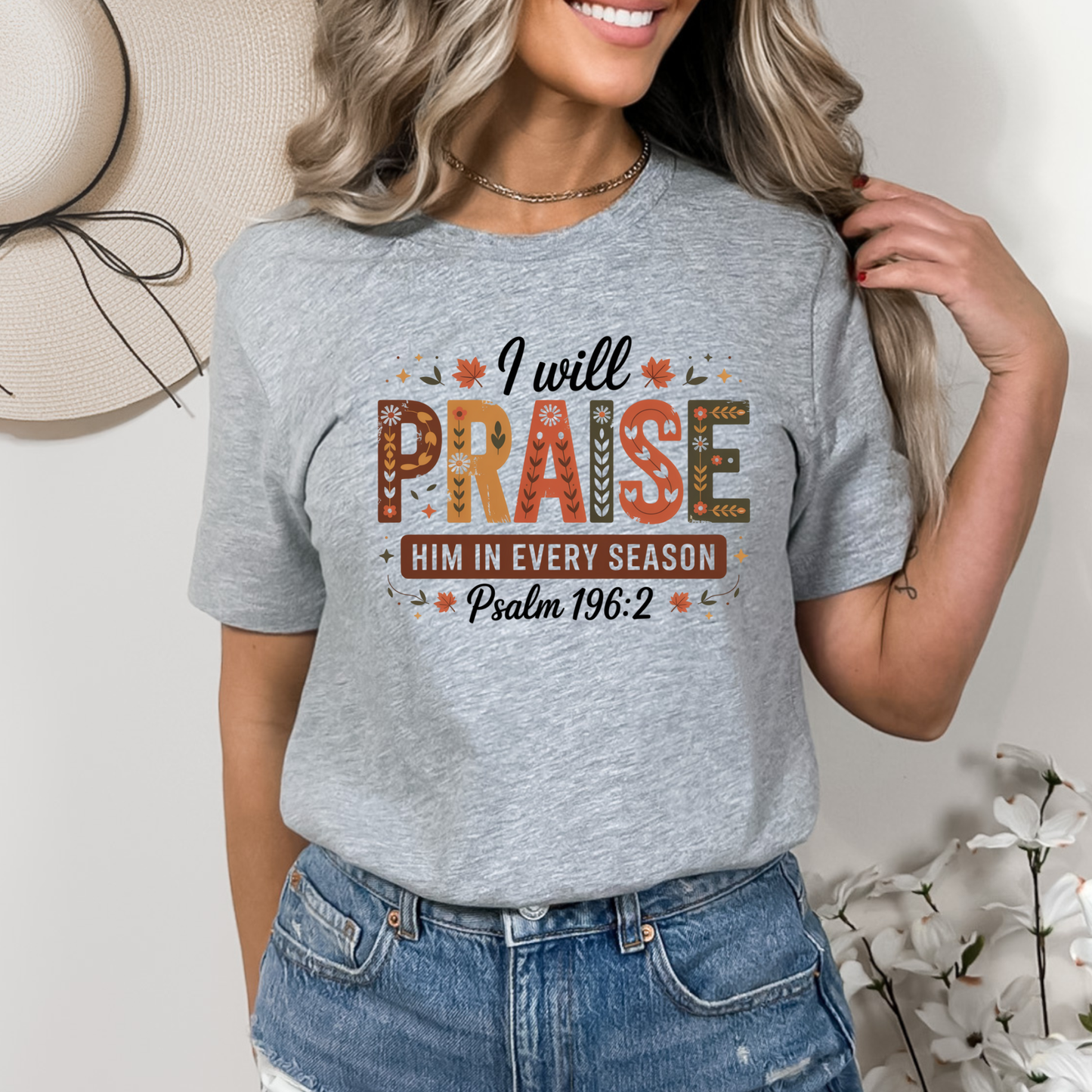 Woman in gray “I Will Praise Him In Every Season” fall faith shirt with rustic background