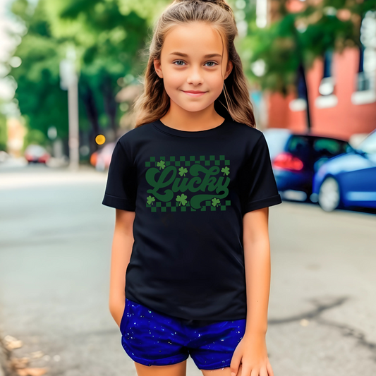 Girl wearing a black trendy St. Patrick’s Day shirt with a stylish lucky shamrock print, great for festive celebrations