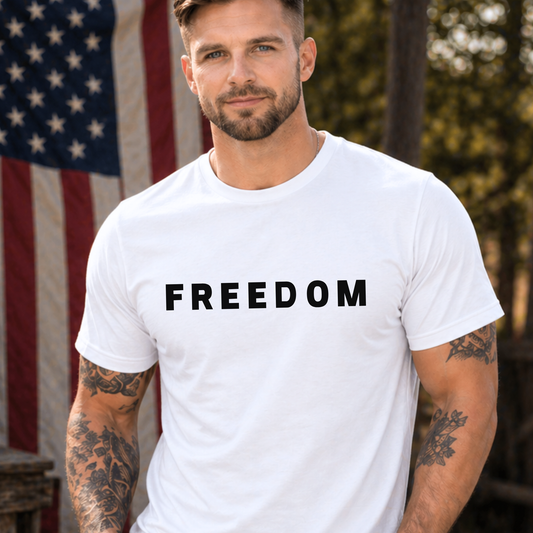 Man wearing a white t-shirt with 'FREEDOM' text in front of an American flag.