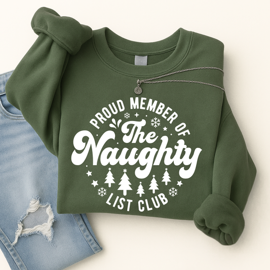 Green sweatshirt folded flat with necklace and jeans – “Proud Member of the Naughty List Club” design.