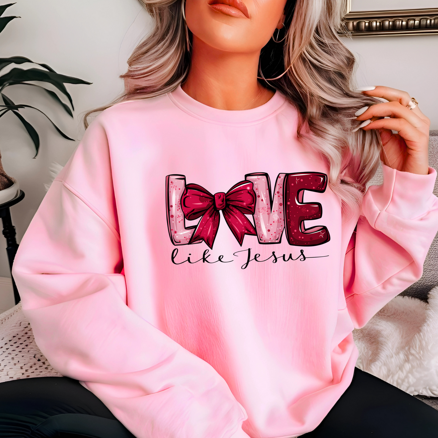 Person wearing a pink sweatshirt with 'LOVE' text and bow design.
