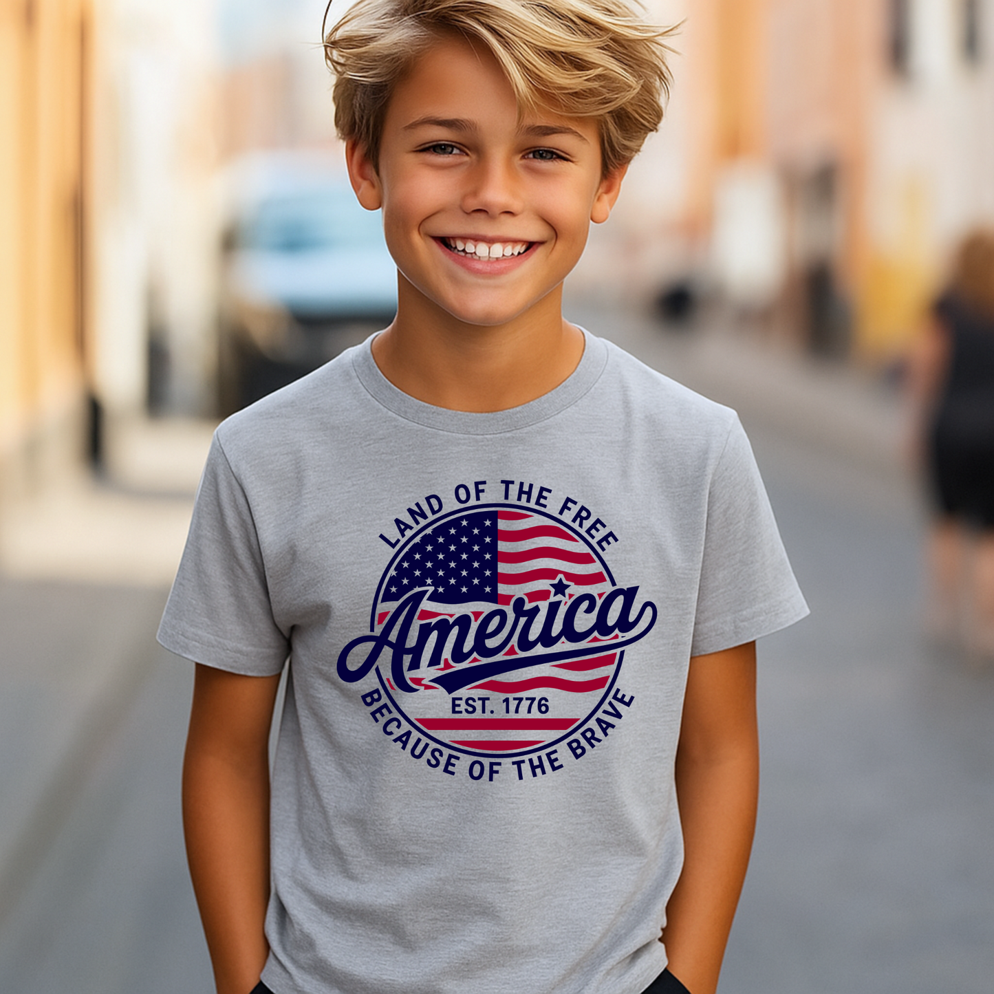 Tween boy wearing light gray patriotic 4th of July shirt with flag emblem