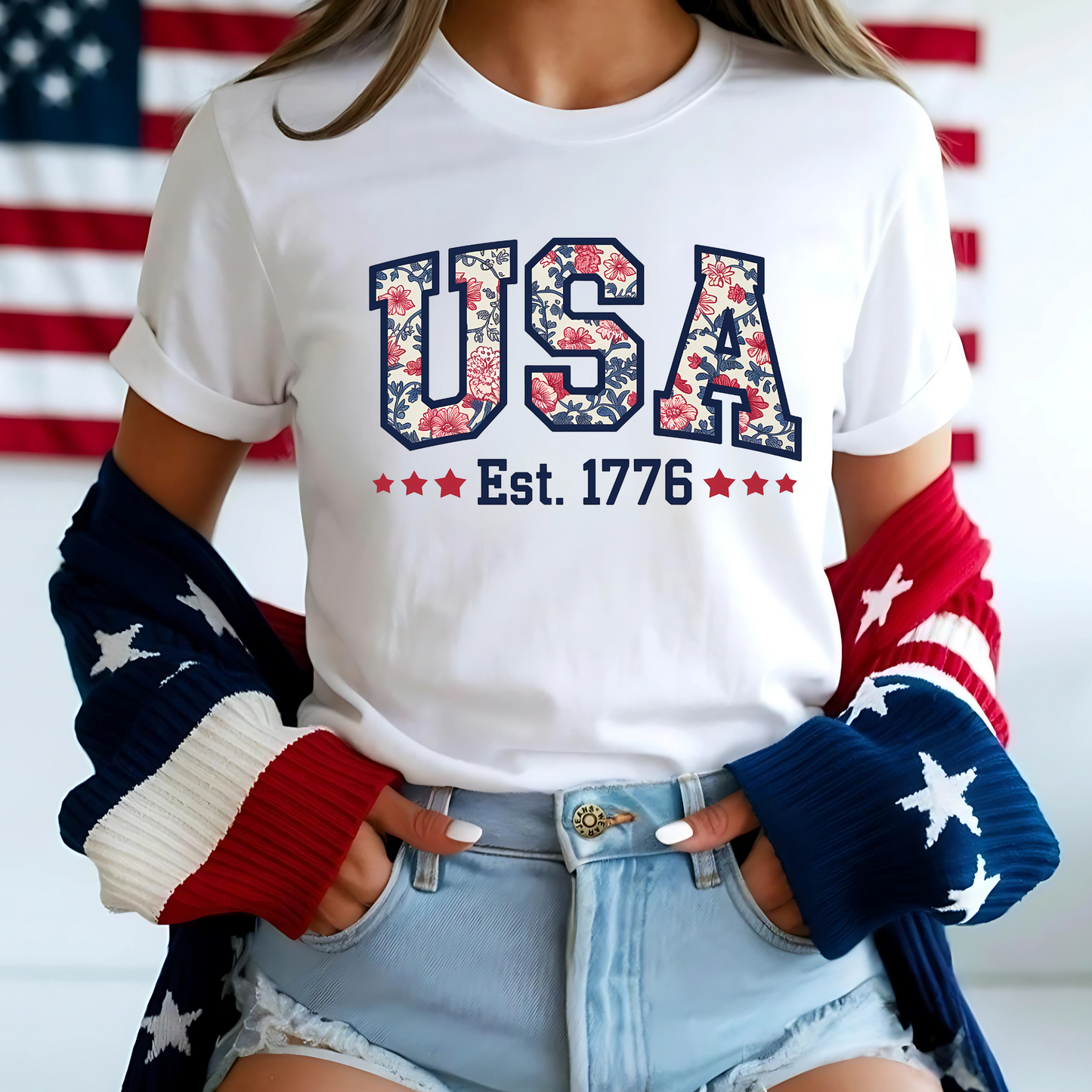 White floral patriotic tee with rolled sleeves – styled with stars-and-stripes cardigan and shorts.