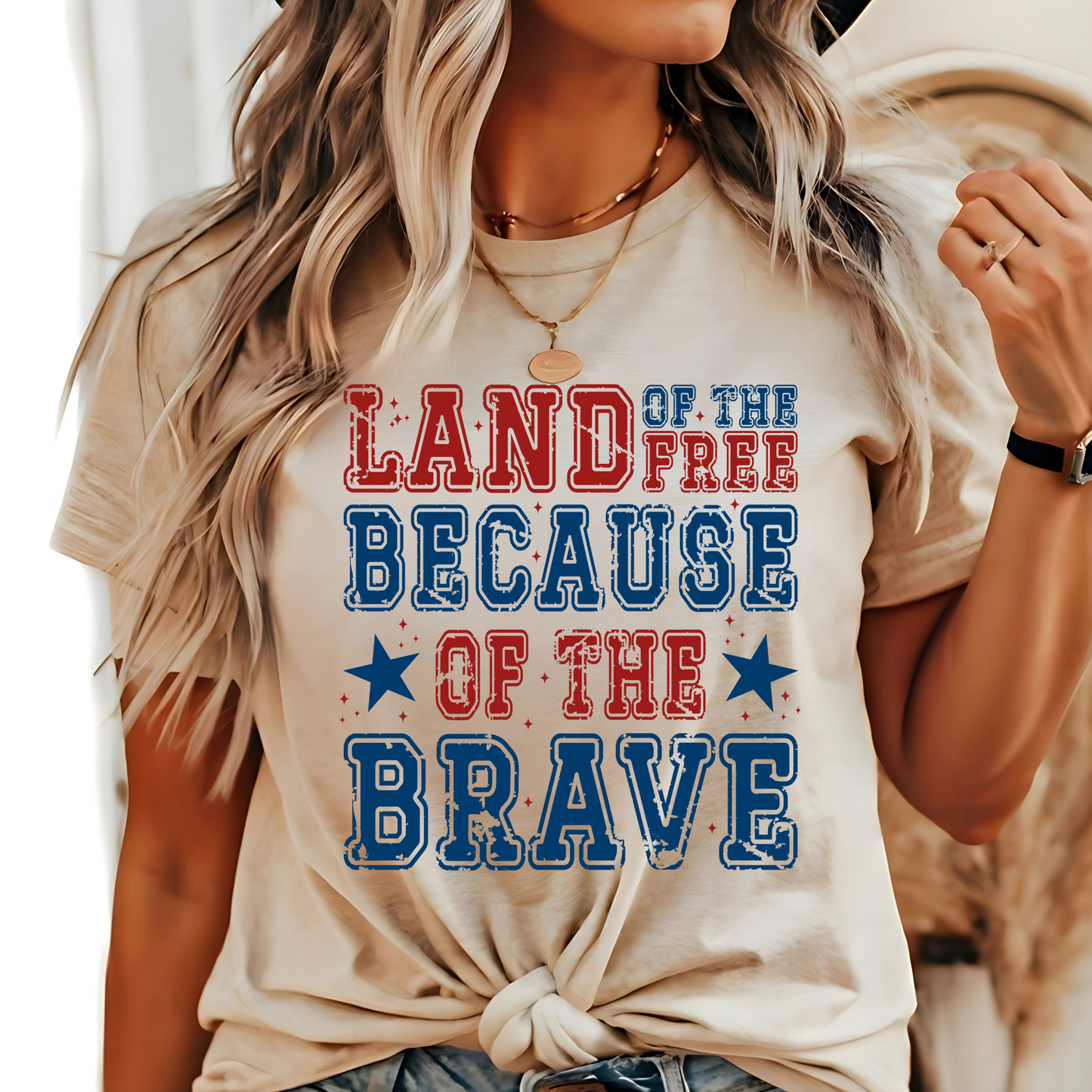 Woman wearing sand-colored tee with bold patriotic lettering and the Statue of Liberty