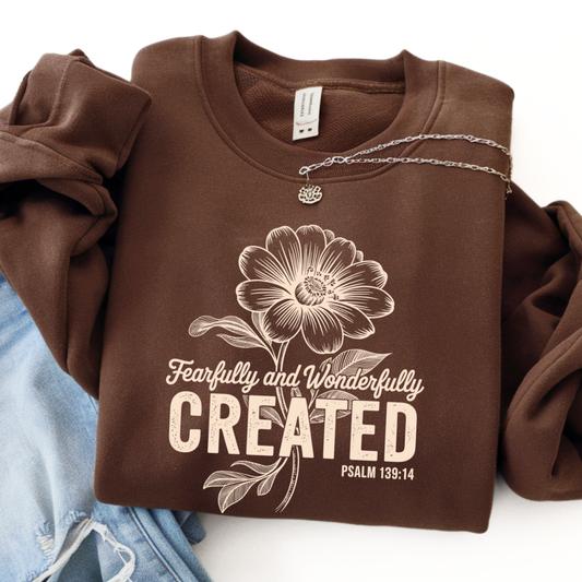 Brown sweatshirt featuring Fearfully and Wonderfully Created floral design with Psalm 139:14 flat lay