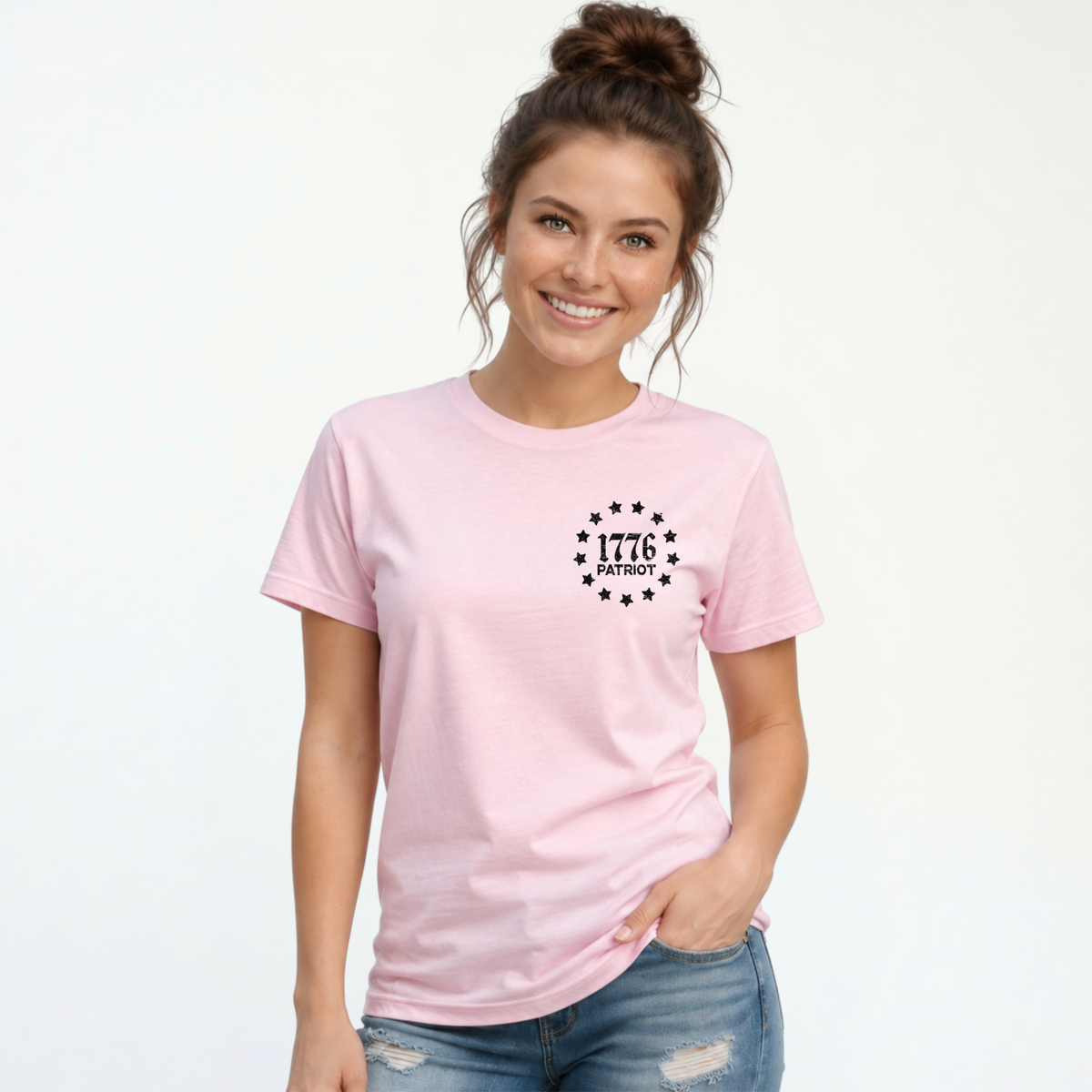 Woman wearing a light pink T-shirt with a black 1776 Patriot emblem on the left chest