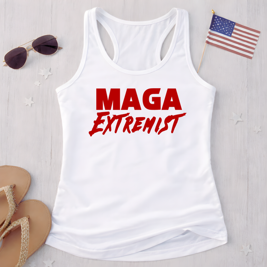 White tank top with 'MAGA Extremist' text on a light wooden surface with sunglasses and an American flag.