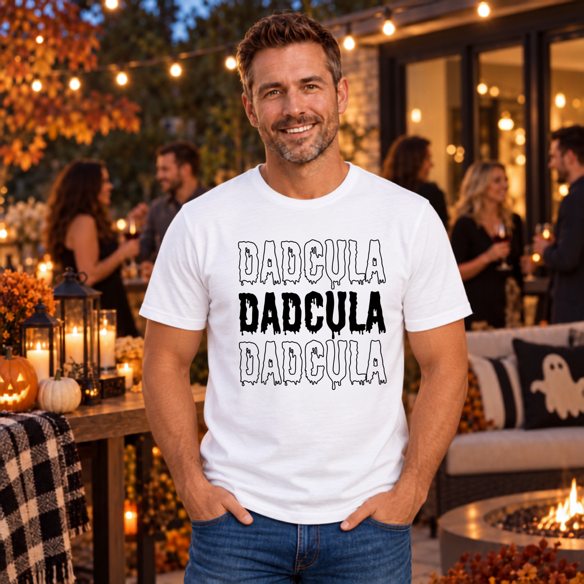 Man modeling the funny DADCULA vampire dad Halloween graphic shirt in a seasonal setting.