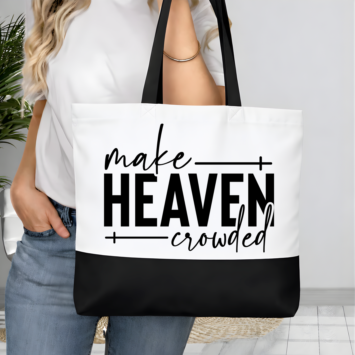 Close-up of Make Heaven Crowded Christian typography printed on white canvas tote bag with black bottom
