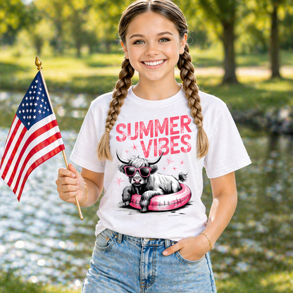 Child wearing a white t-shirt with 'Summer Vibes' graphic design while holding an American Flag on the lake