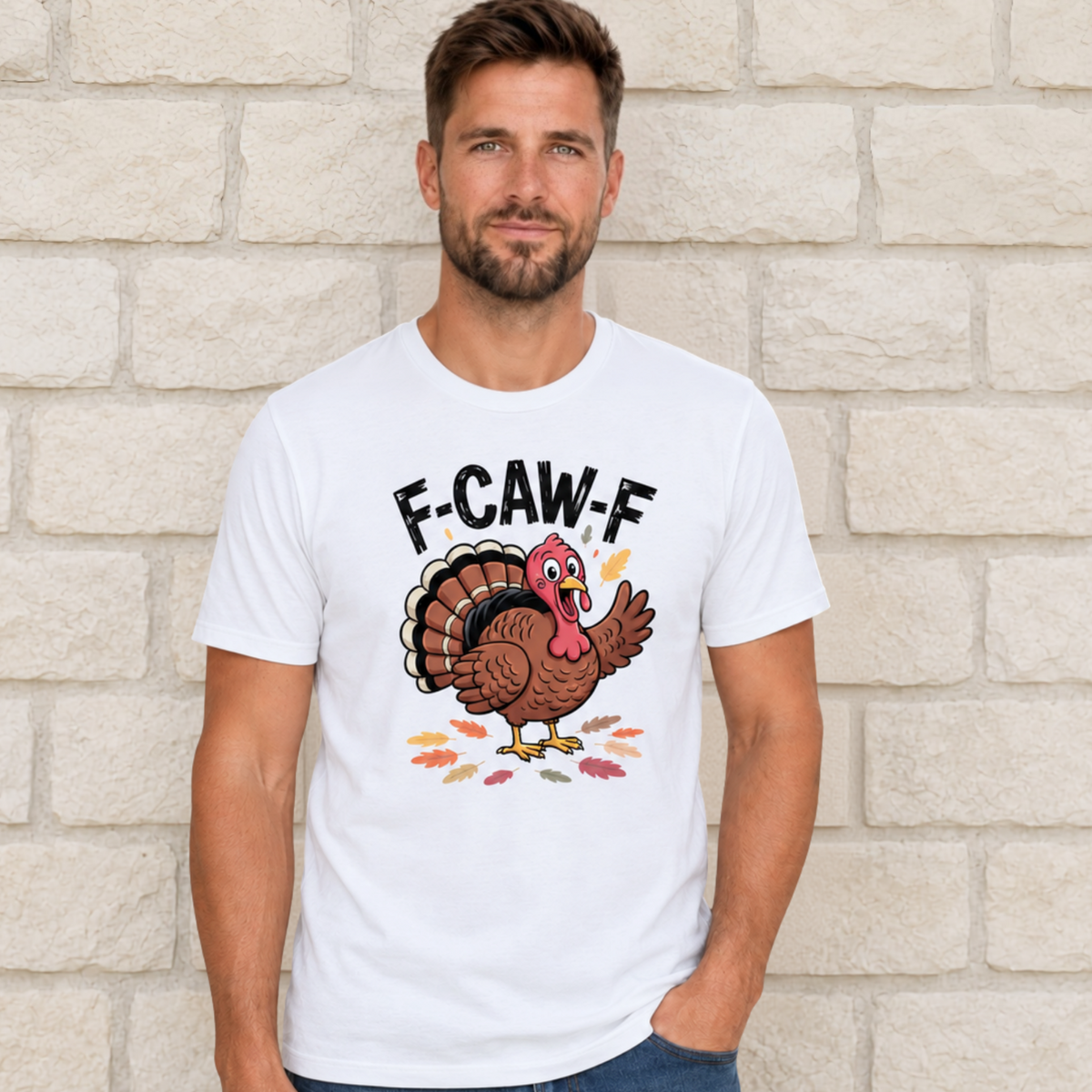 Man wearing a white T-shirt with a colorful F-CAW-F turkey graphic against a light stone wall.