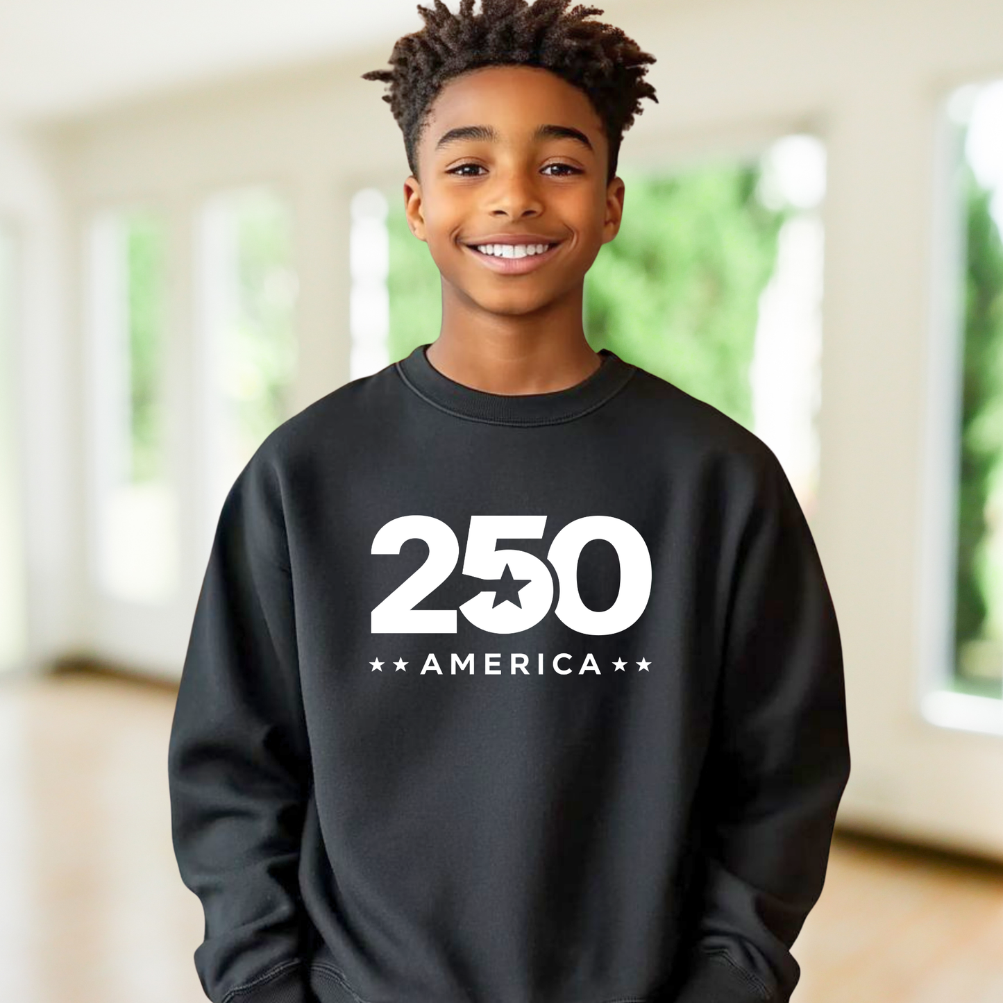 Boy wearing a black sweatshirt with '250 America' printed on it, standing indoors.