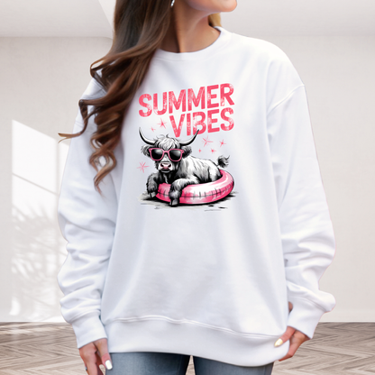 White sweatshirt with 'Summer Vibes' graphic design featuring a highland  cow on a pink pool float.