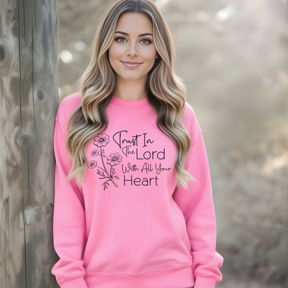 Woman wearing a pink sweatshirt with a motivational quote against a natural background