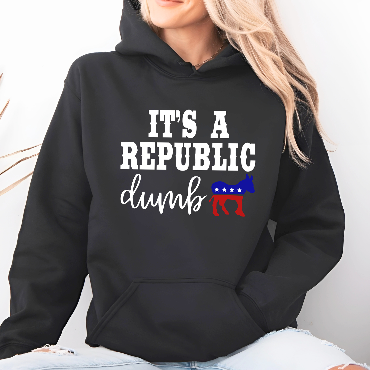 Person wearing a black hoodie with political text and symbols