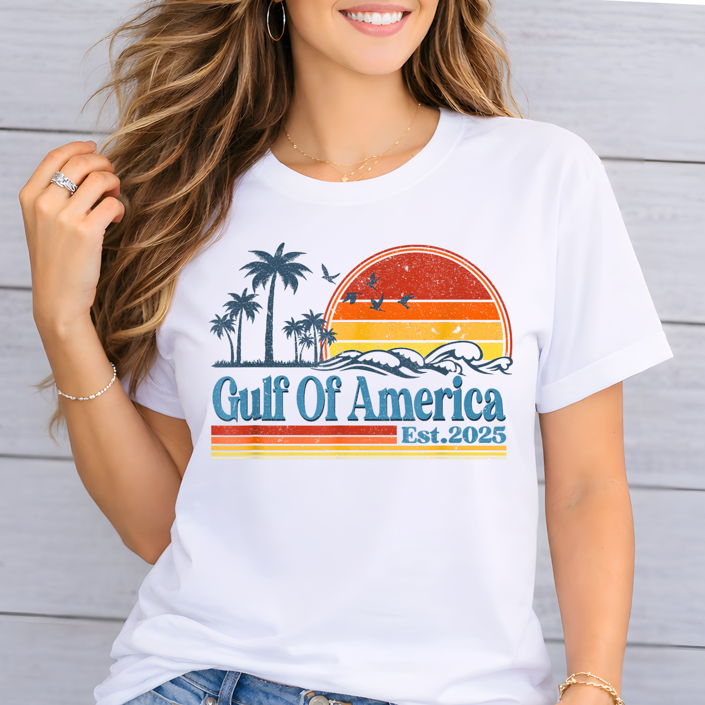 Woman wearing a white t-shirt with 'Gulf Of America Est. 2025' design against a wooden background