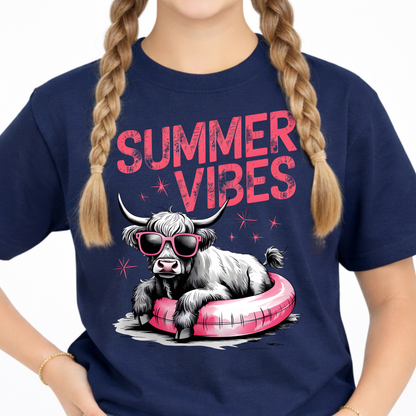 Close up of a youth navy blue t-shirt with a highland cow graphic and 'Summer Vibes' text.