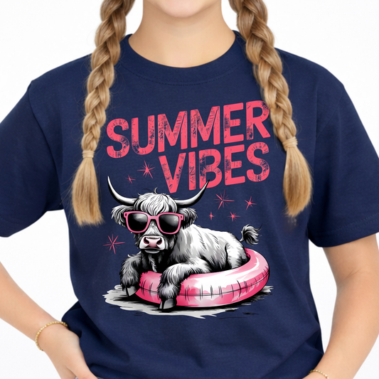 Close up of a youth navy blue t-shirt with a highland cow graphic and 'Summer Vibes' text.