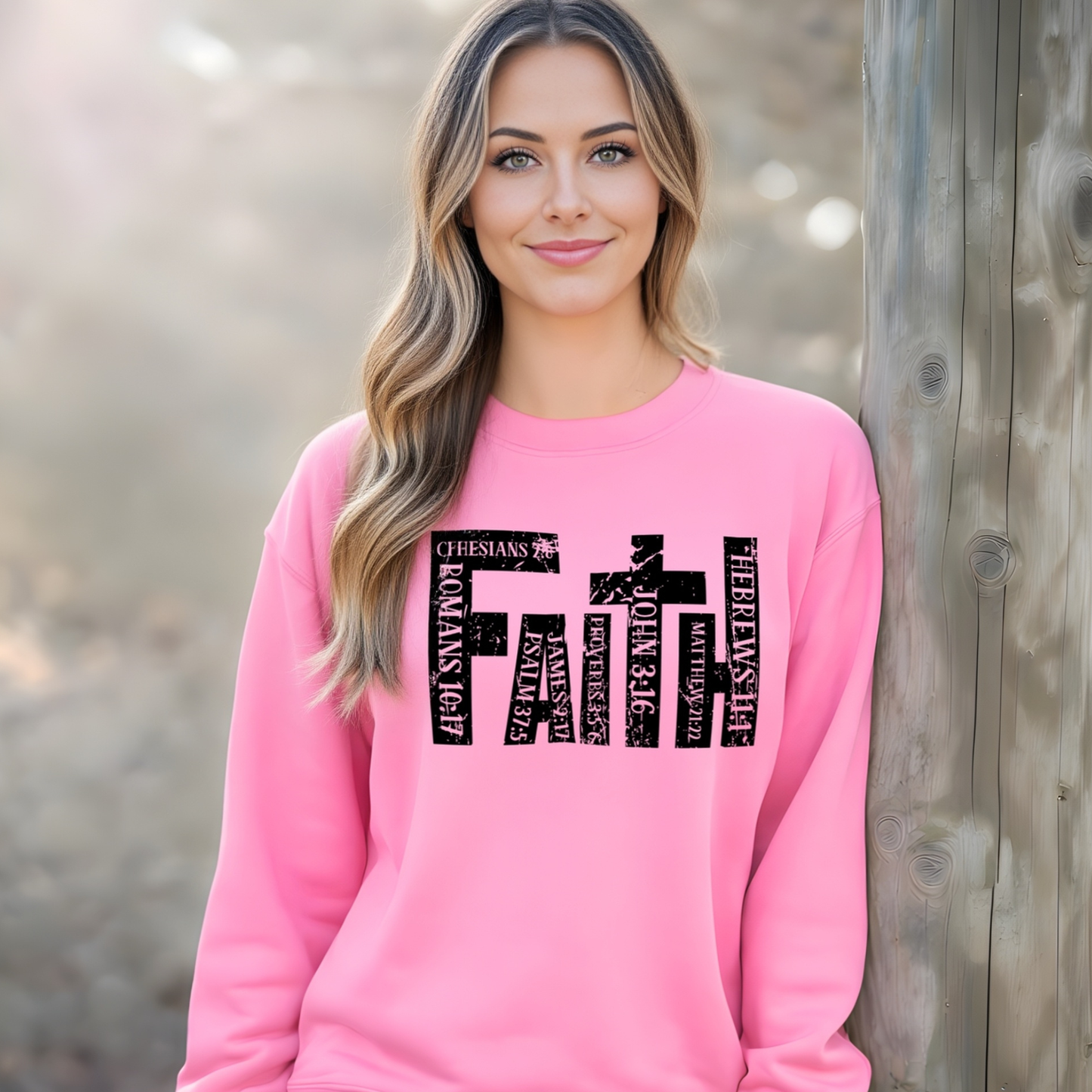 Woman wearing a pink sweatshirt with text design, standing against a wooden background.