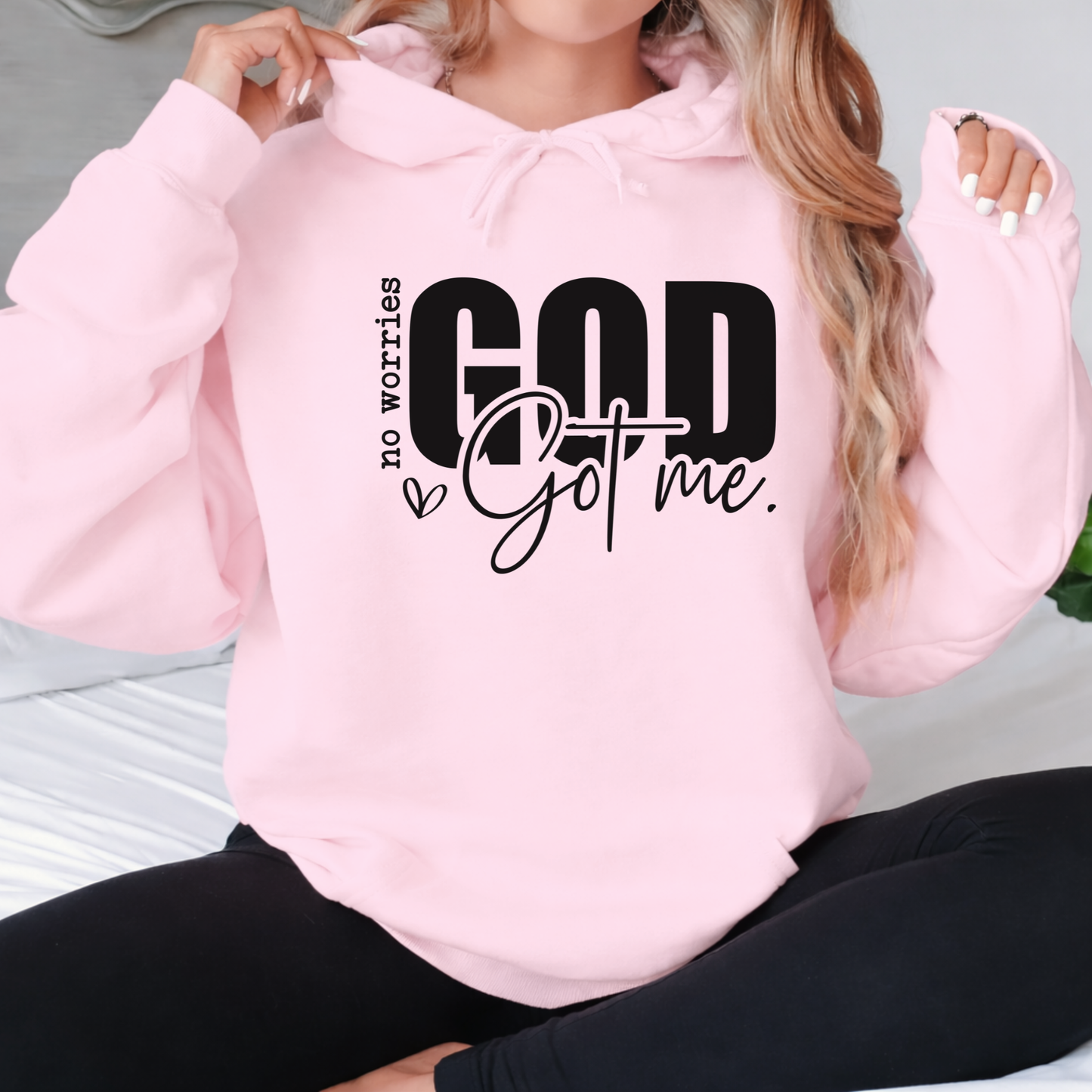 Woman wearing a pink shirt with text "No Worries GOD Got me"