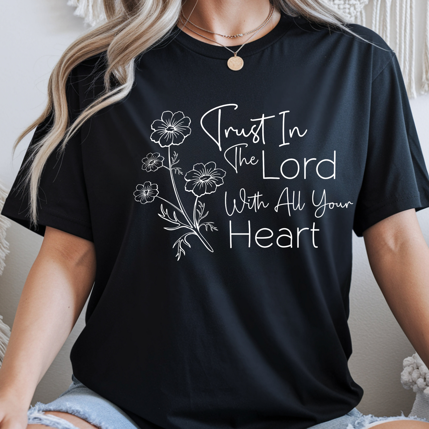 Black t-shirt with floral design and text worn by a person