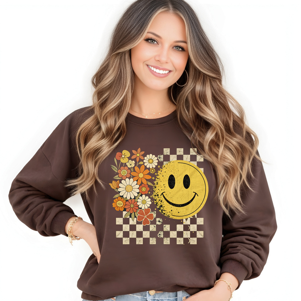 Woman wearing a brown sweatshirt with a retro smiley face and floral design on a white background