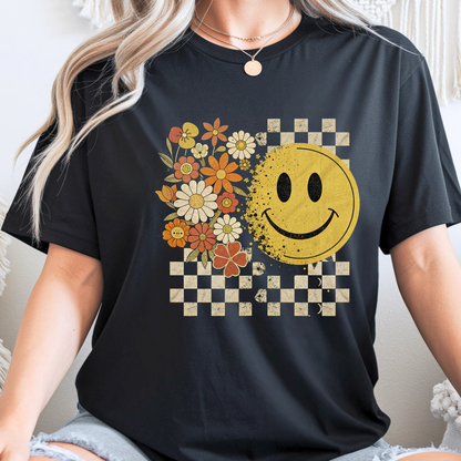 Woman wearing a black t-shirt with a smiley face and floral design.