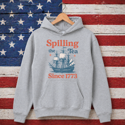 Gray hoodie with ship graphic and text 'Spilling the Tea Since 1773' on an American flag background