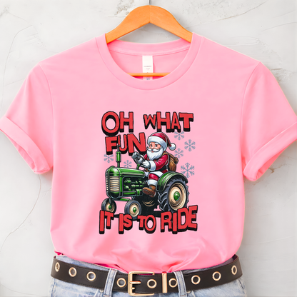 Pink t-shirt with Santa driving a tractor graphic and text on a hanger.