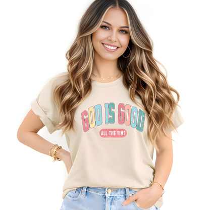 Woman wearing a beige t-shirt with 'God is Good All the Time' text on a white background