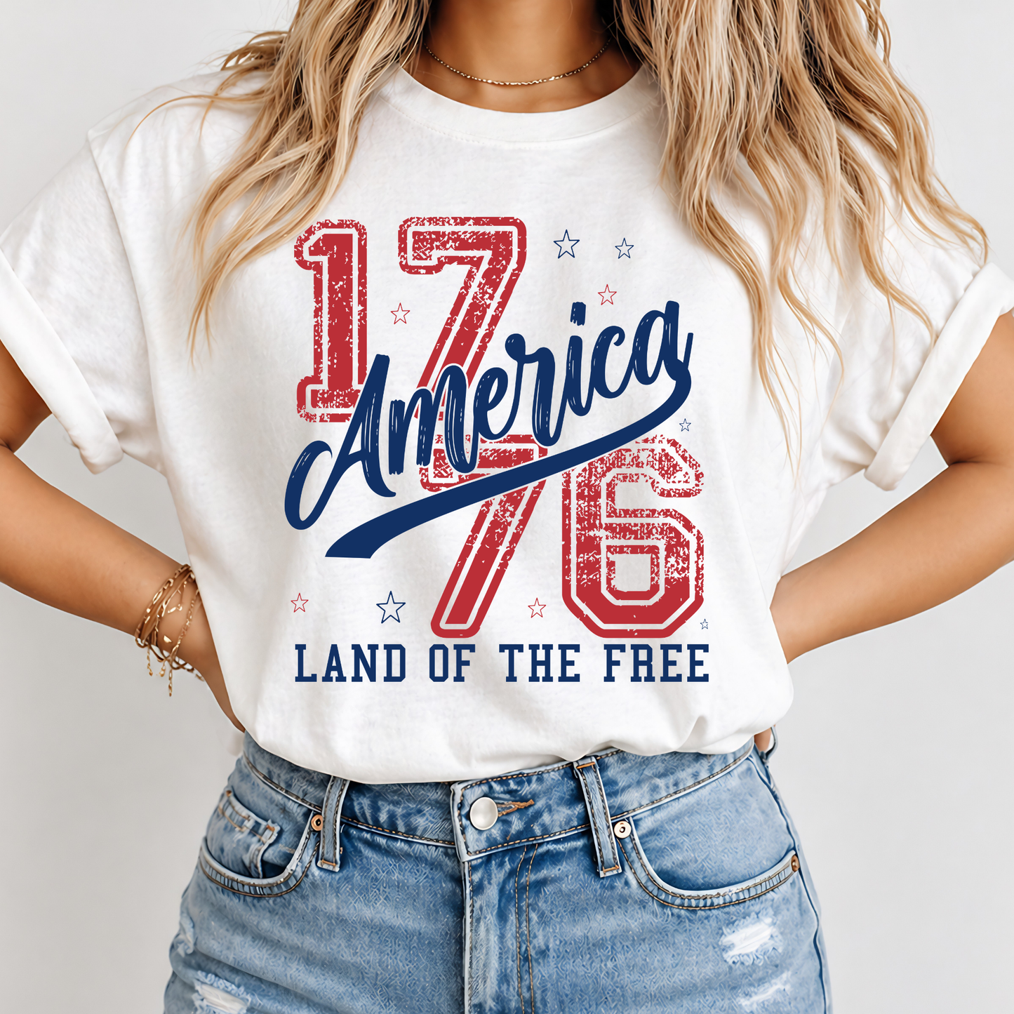 Person wearing a white t-shirt with 'America 1776 Land of the Free' design.