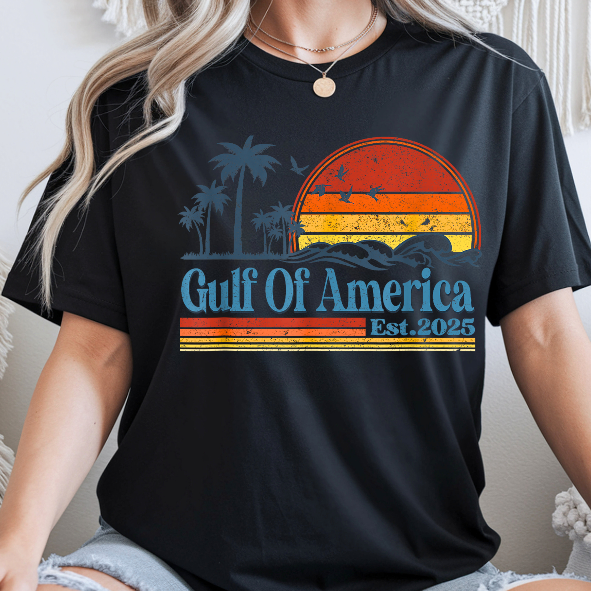 Woman  wearing a black t-shirt with 'Gulf Of America Est. 2025' design.
