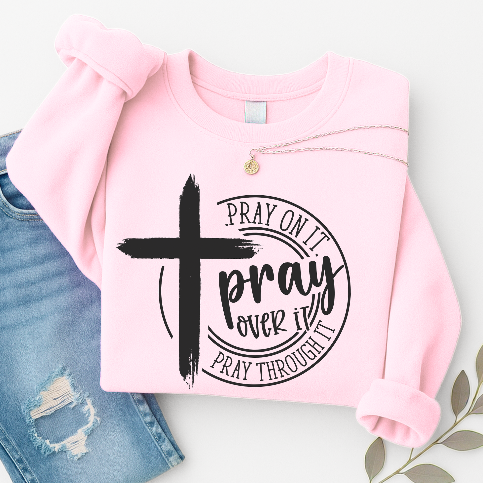 Pink sweatshirt with a cross and text design on a white background