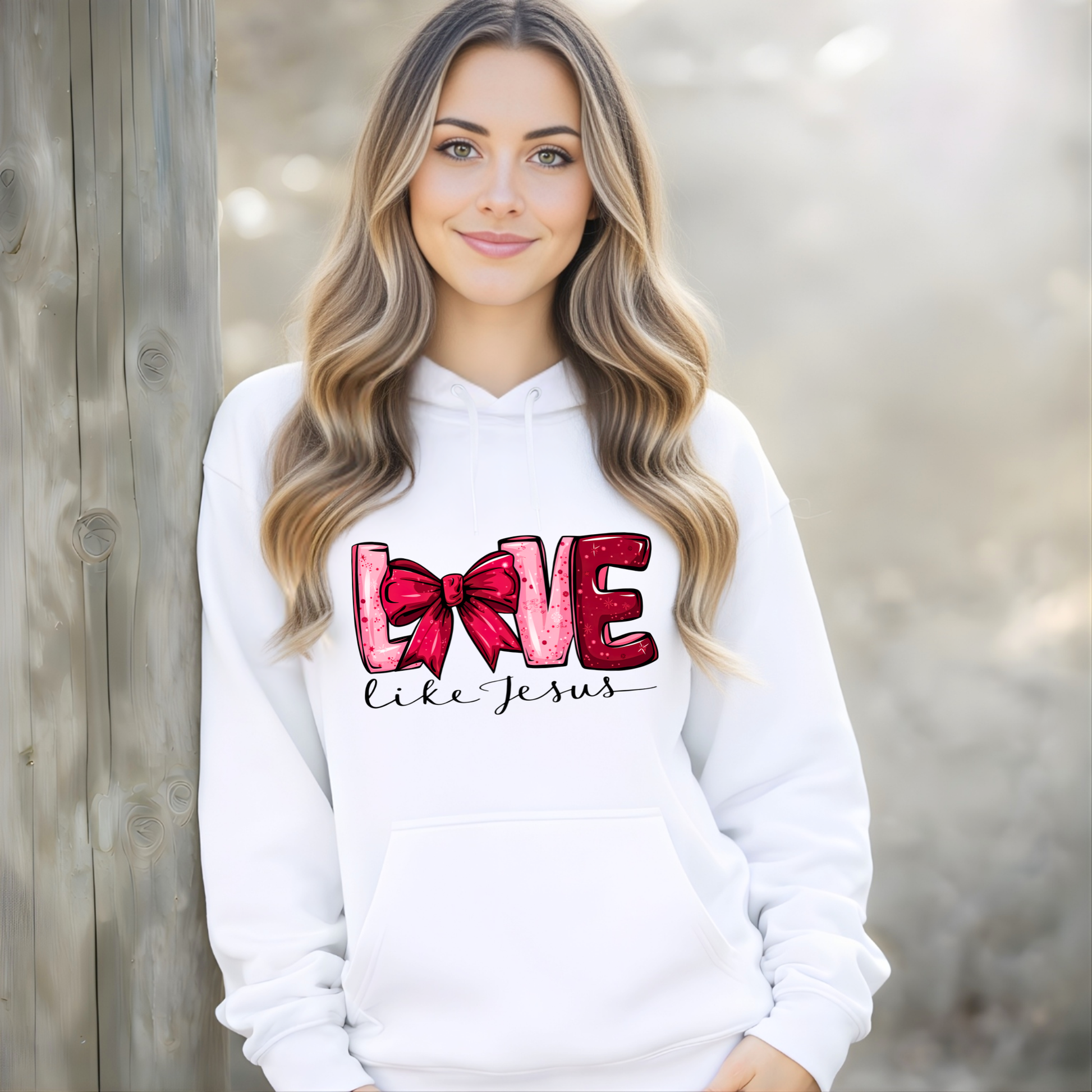 Woman wearing a white hoodie with 'Love like Jesus' design, standing against a wooden background.