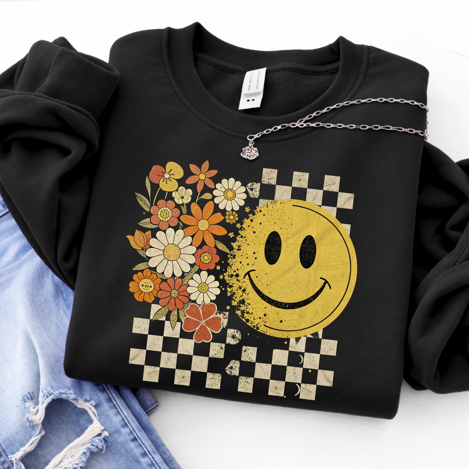 Black hoodie with a retro smiley face and floral design on a white background