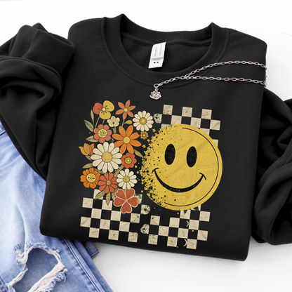 Black hoodie with a retro smiley face and floral design on a white background