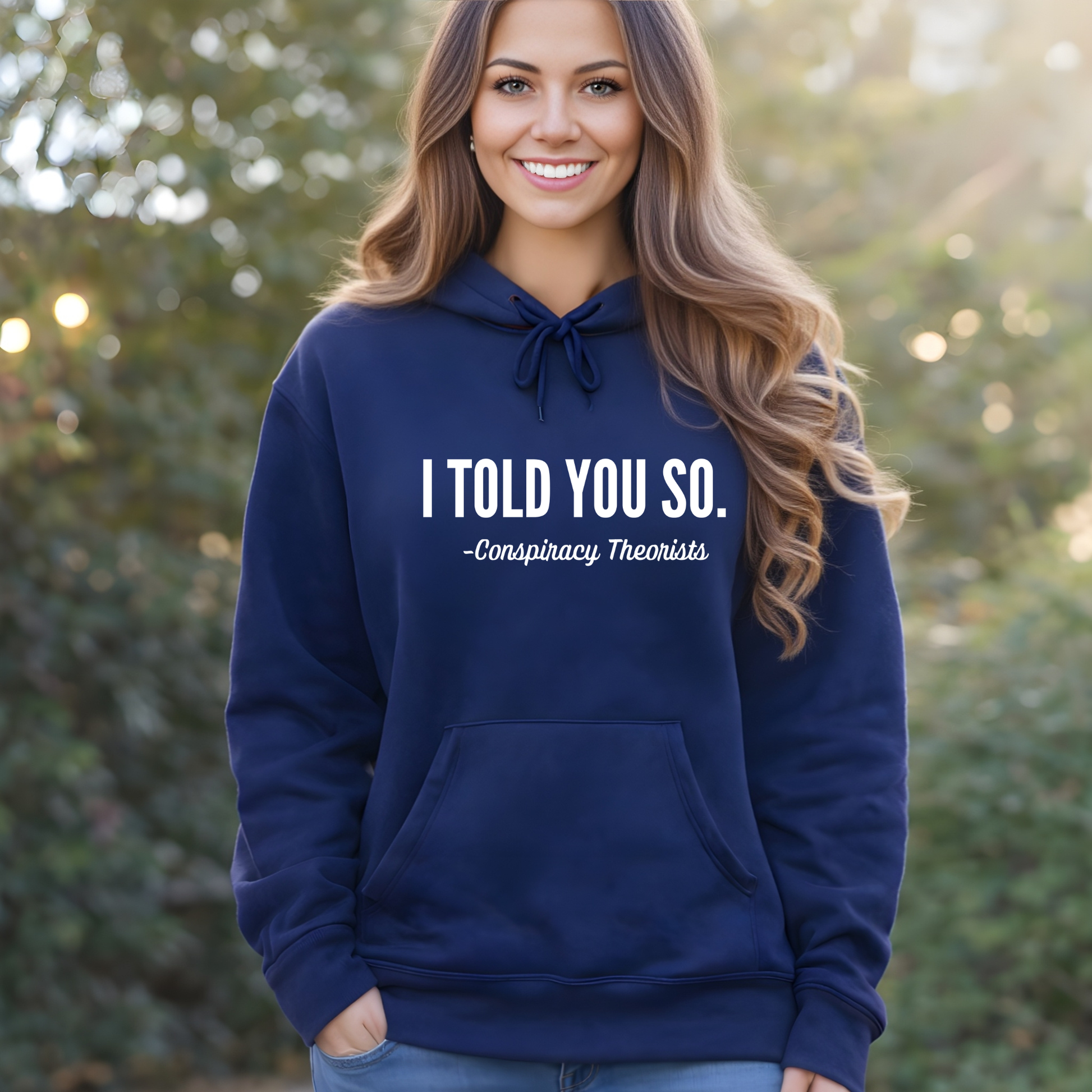 Woman wearing a navy blue Conspiracy Threorists hoodie with text, standing outdoors.