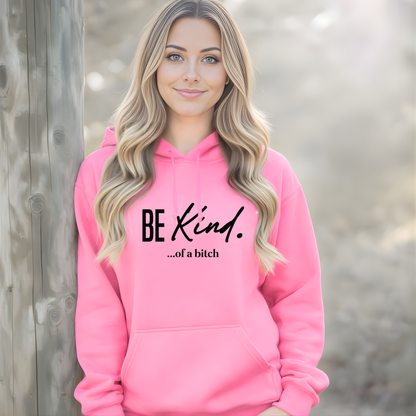 Woman wearing a pink hoodie with 'BE KIND...of a bitch' text.