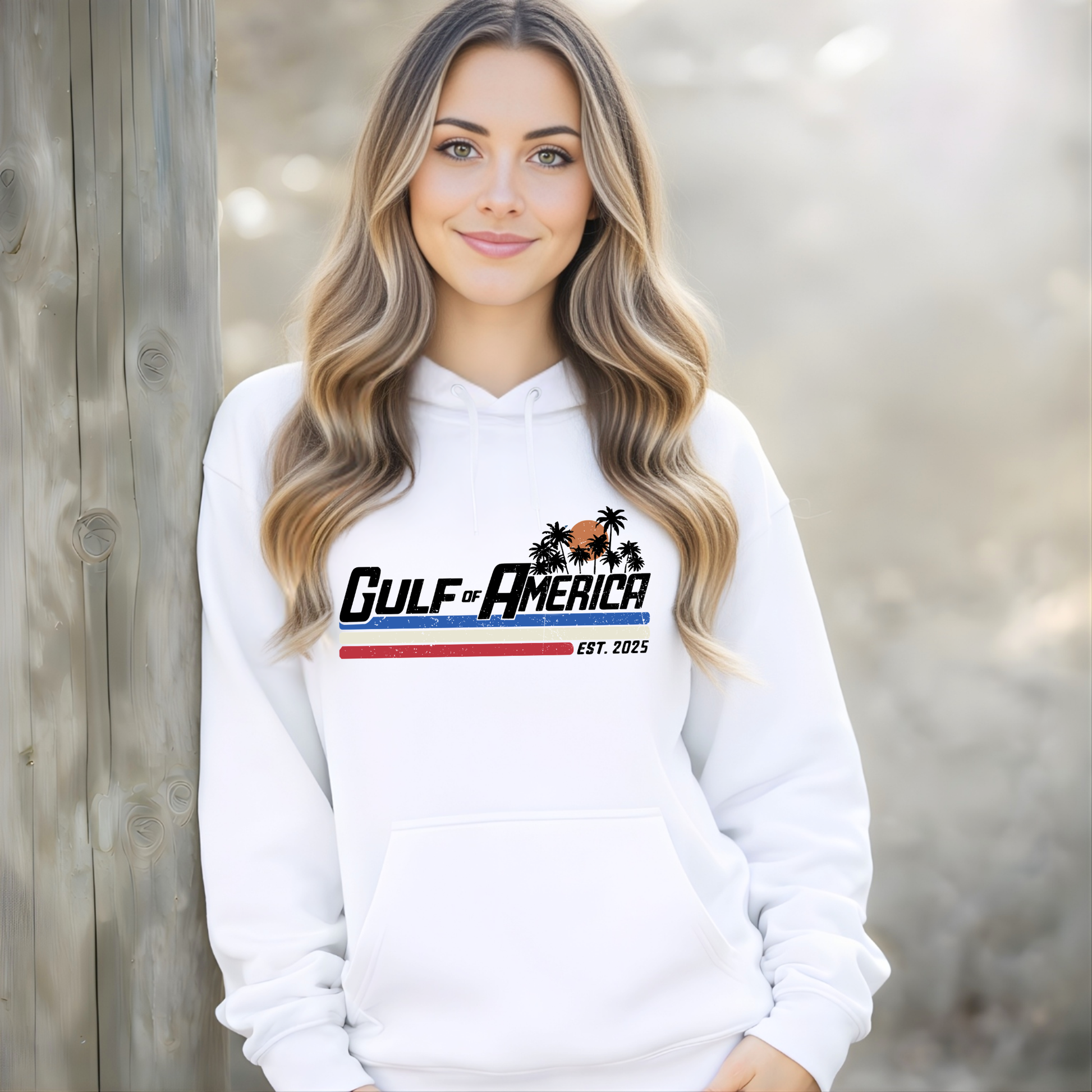 Woman wearing a white hoodie with 'Gulf of America' logo against a wooden background