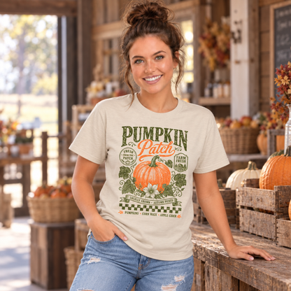 Woman wearing a sand T-shirt with vintage Pumpkin Patch pumpkin and floral design inside a rustic farm stand