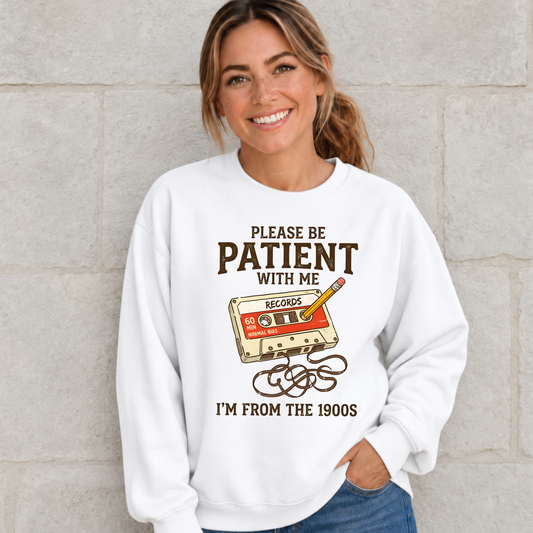 Woman wearing a white Gen X sweatshirt featuring a cassette tape and “Please Be Patient With Me, I’m From the 1900s” graphic.