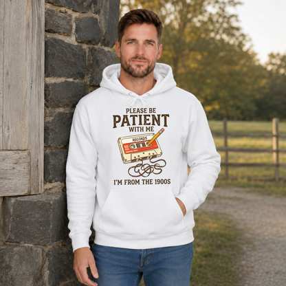 Man wearing a white hoodie with the Please Be Patient With Me, I’m From the 1900s cassette tape and pencil graphic.