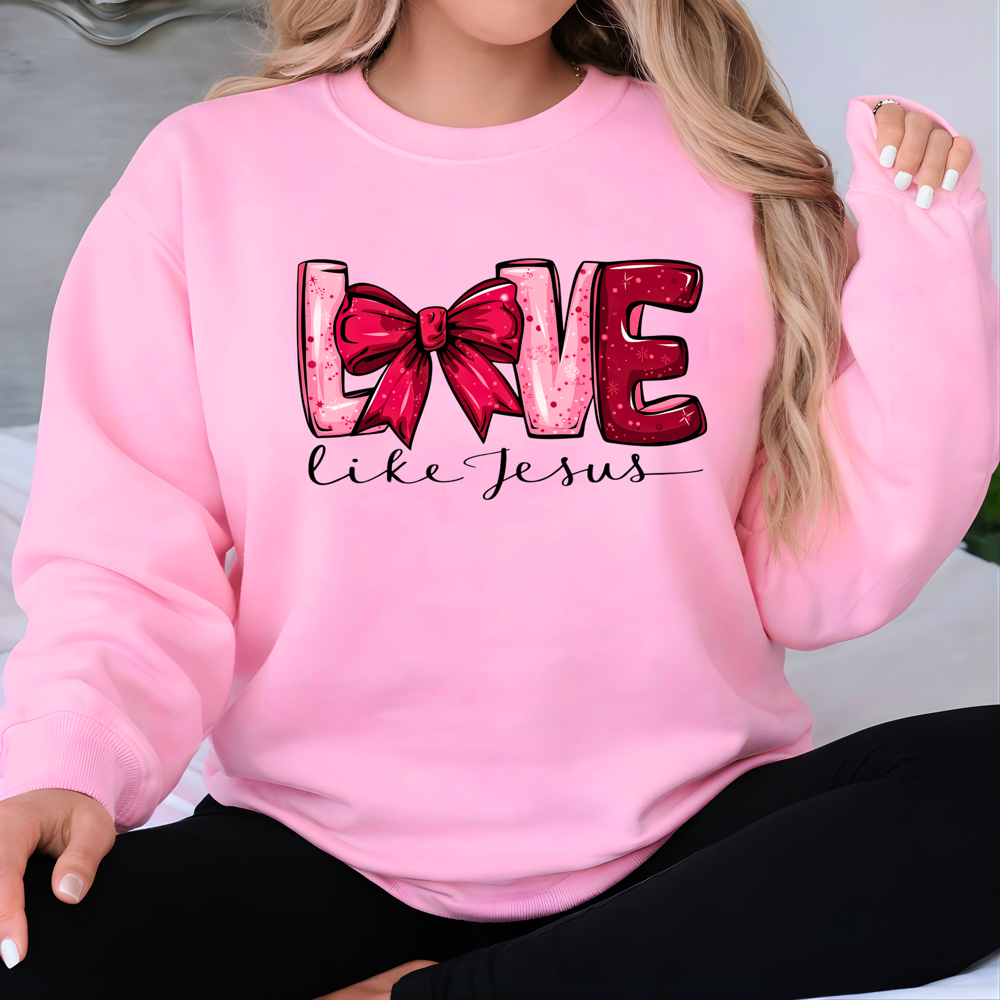 Pink sweatshirt with 'Love like Jesus' text and red bow graphic