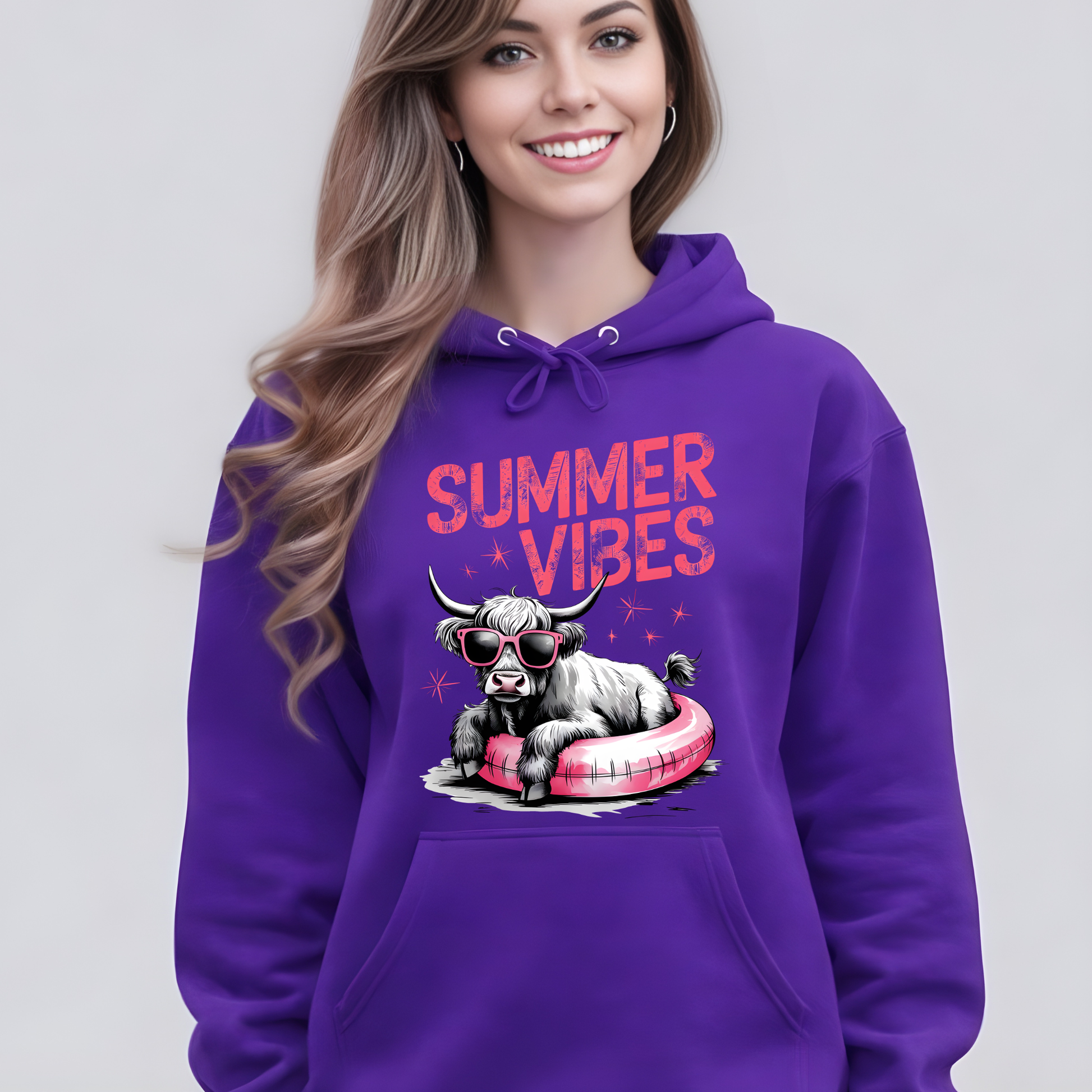 Woman wearing a purple hoodie with a highland cow graphic and 'Summer Vibes' text on a plain background