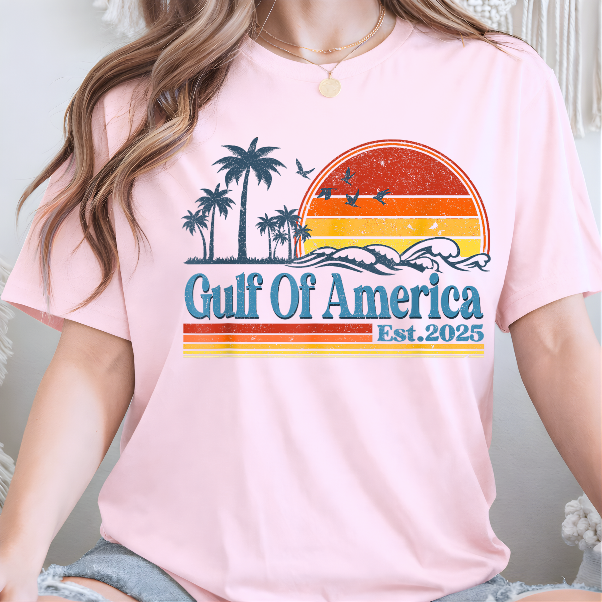 Person wearing a pink t-shirt with 'Gulf Of America Est. 2025' design.