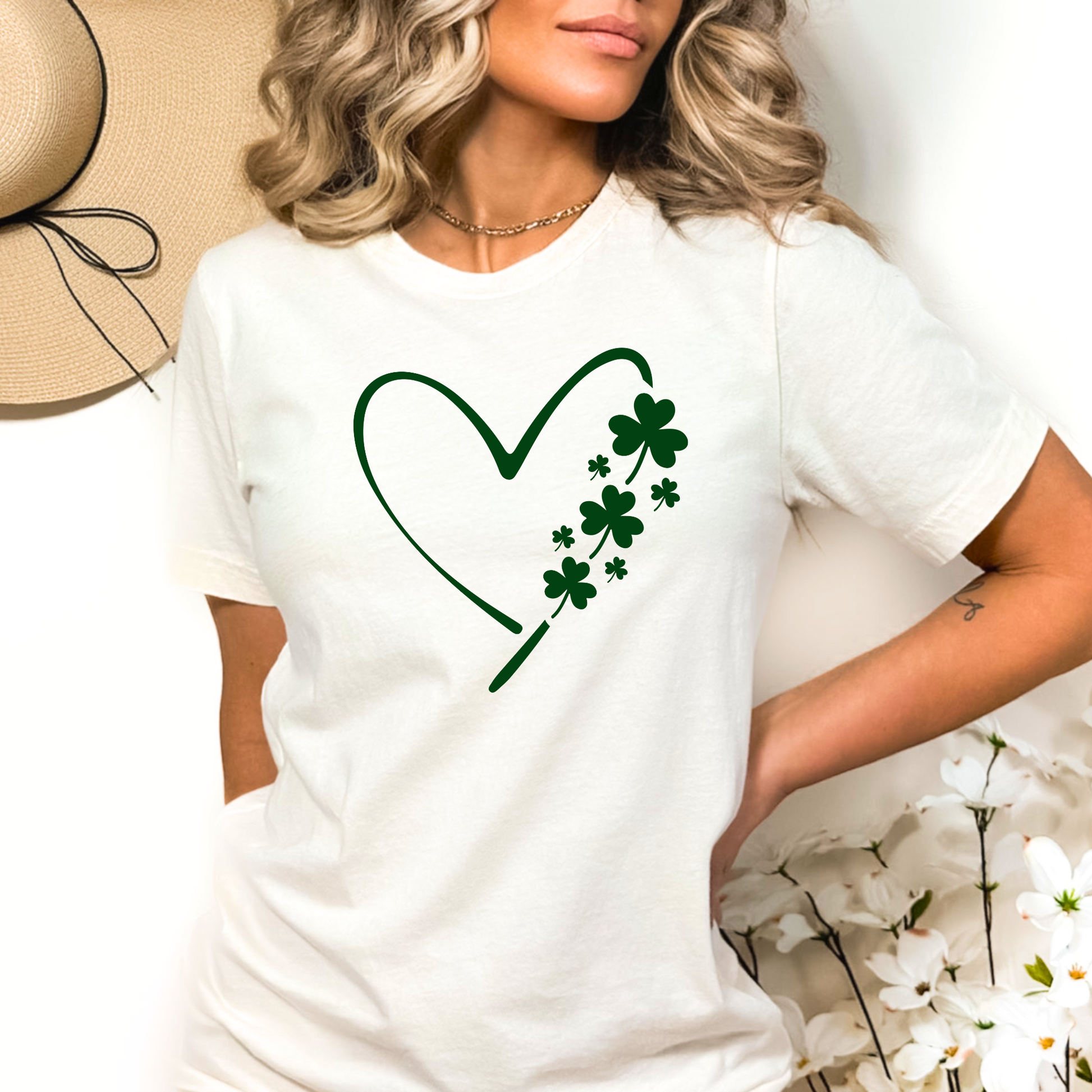 A woman wearing a white T-shirt with a minimalist green heart and shamrock design, perfect for St. Patrick’s Day celebrations.
