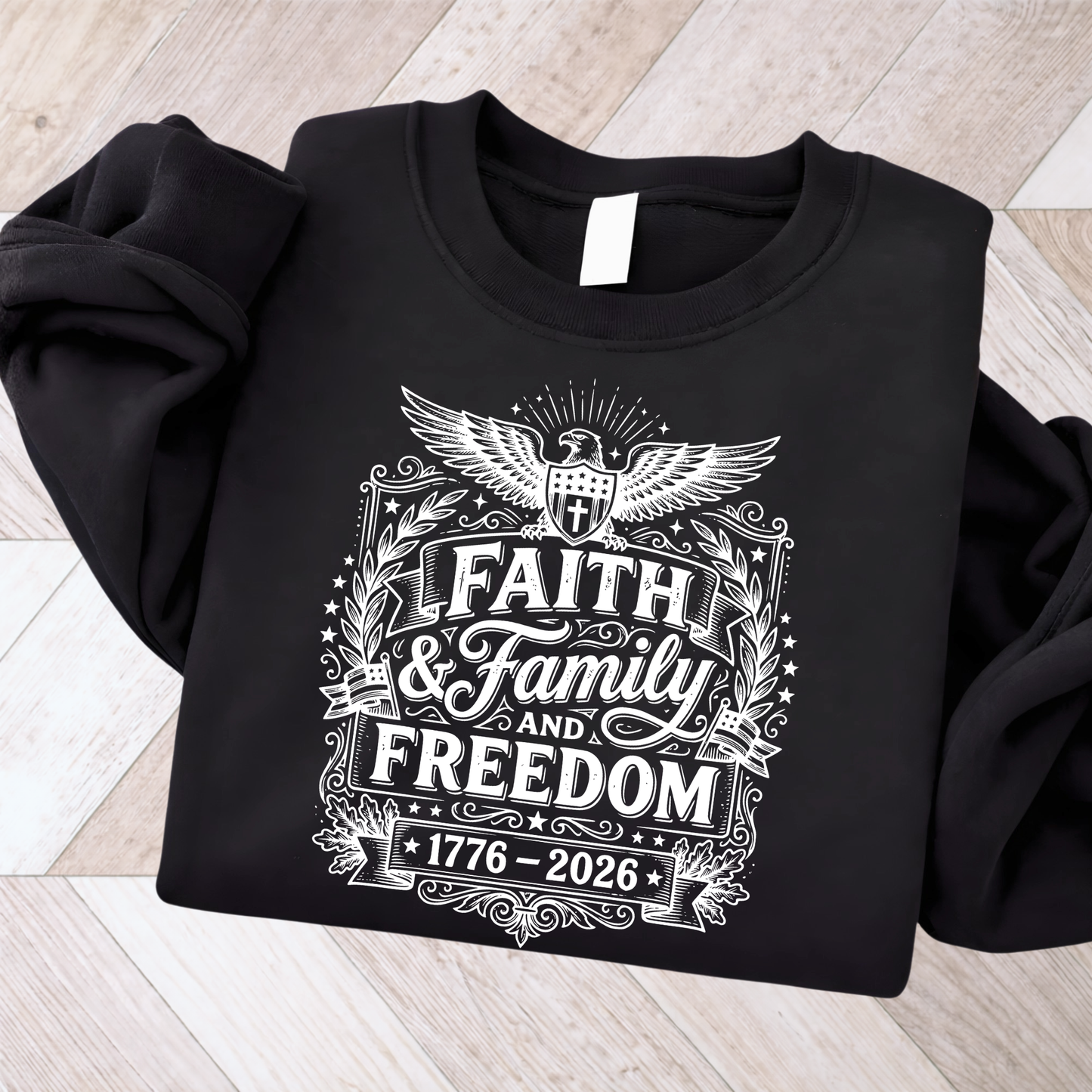 Black sweatshirt with 'Faith & Family & Freedom 1776-2026' design on a wooden surface